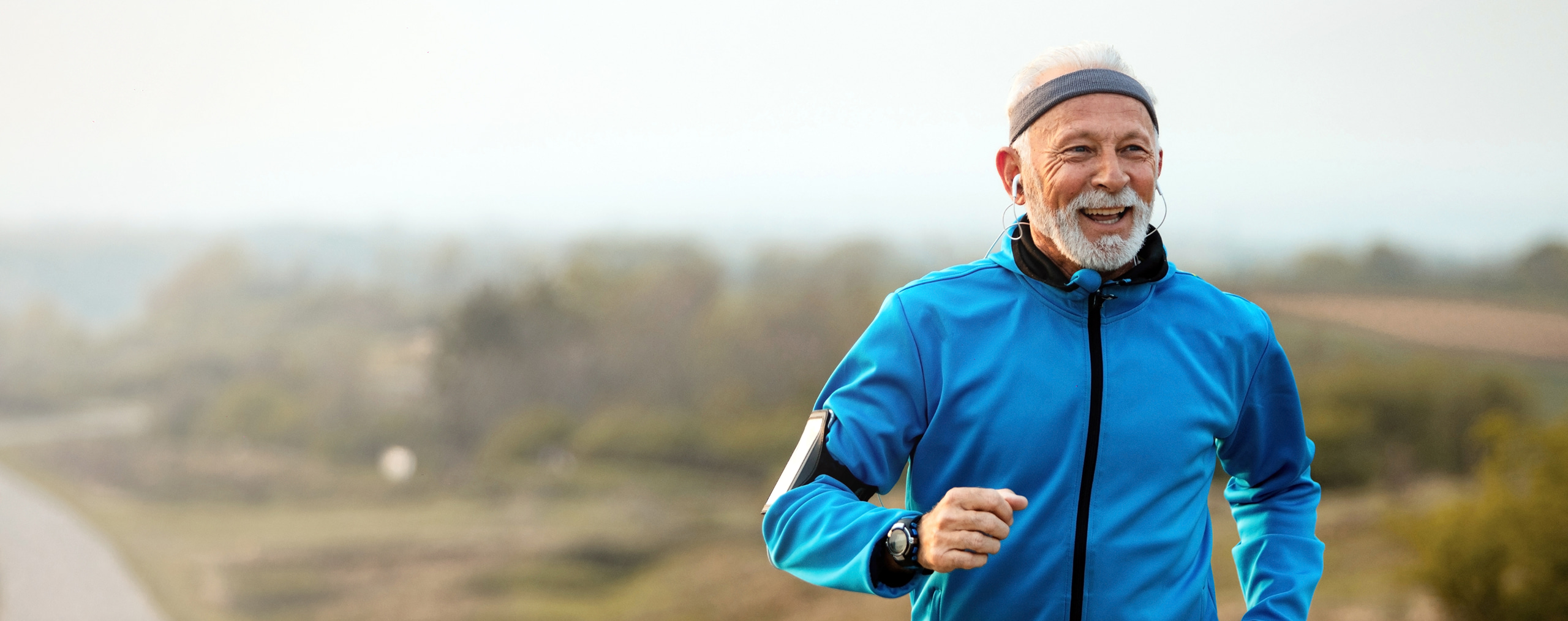 Hombre mayor corriendo al aire libre con una sonrisa